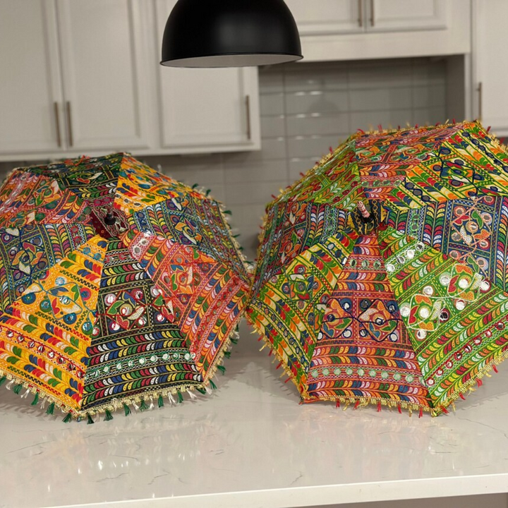 Two embroidered Indian decorative umbrellas with colorful panels, mirror details and tassel trim