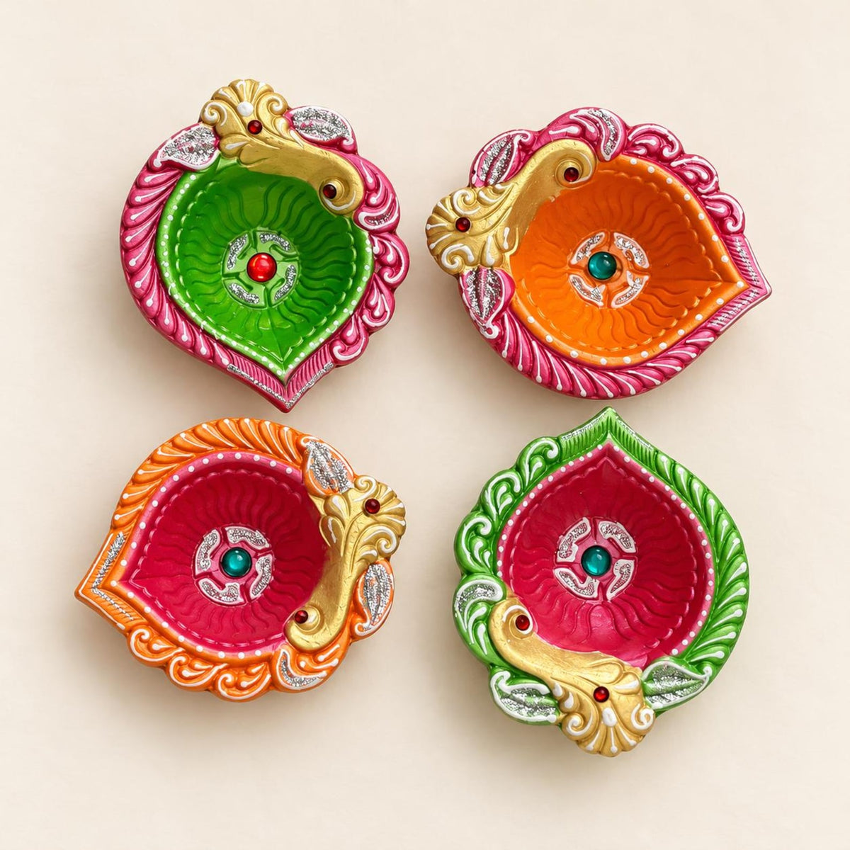Set of four empty peacock-shaped clay diyas with pink, orange and green paint and gold-toned decorative details