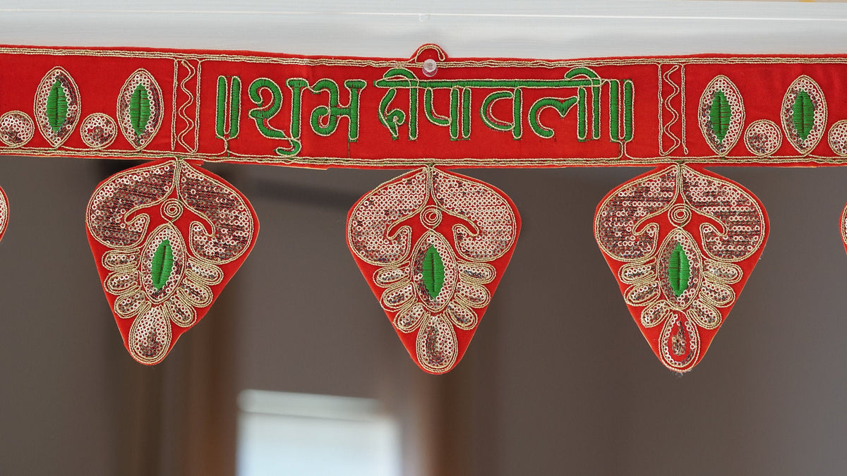 Red Shubh Deepawali embroidered toran with green lettering and hanging leaf panels