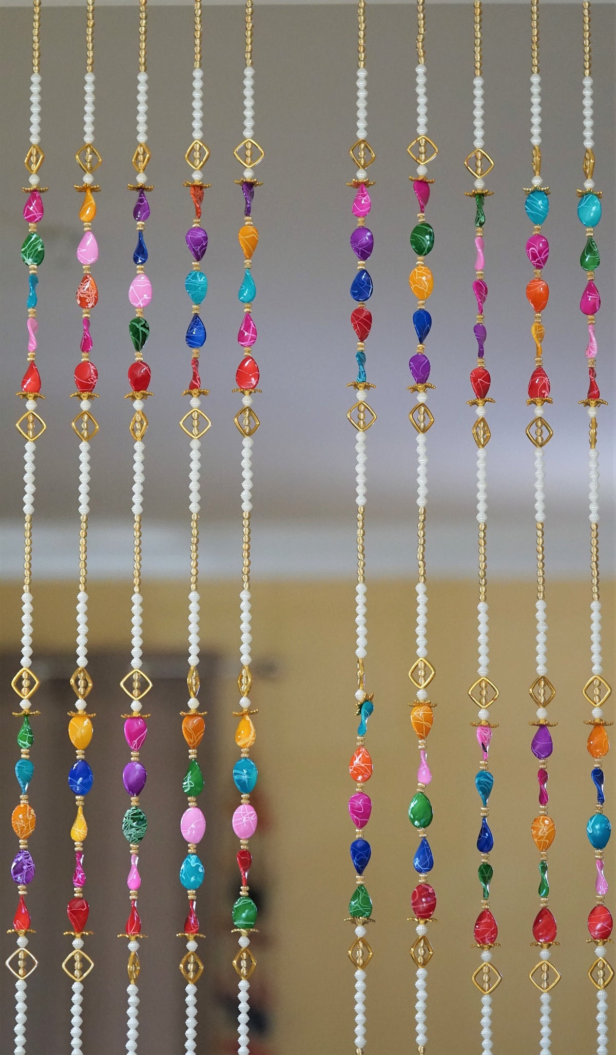 Detail of multicolor acrylic bead groups and long pearl-style sections in the curtain design