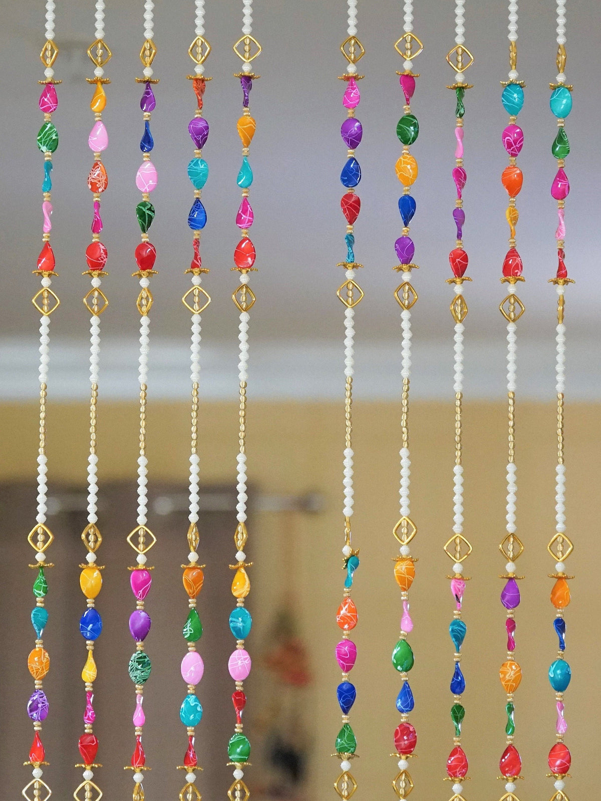 Detail of multicolor acrylic bead groups and long pearl-style sections in the curtain design