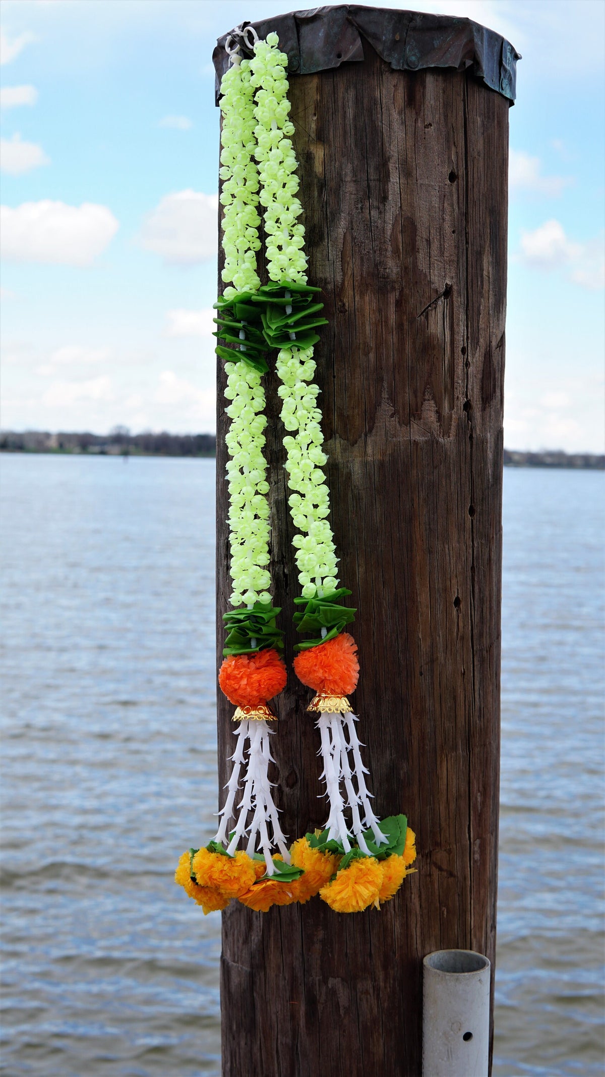 Detail of jasmine-style garland hangings with green accents and orange flowers