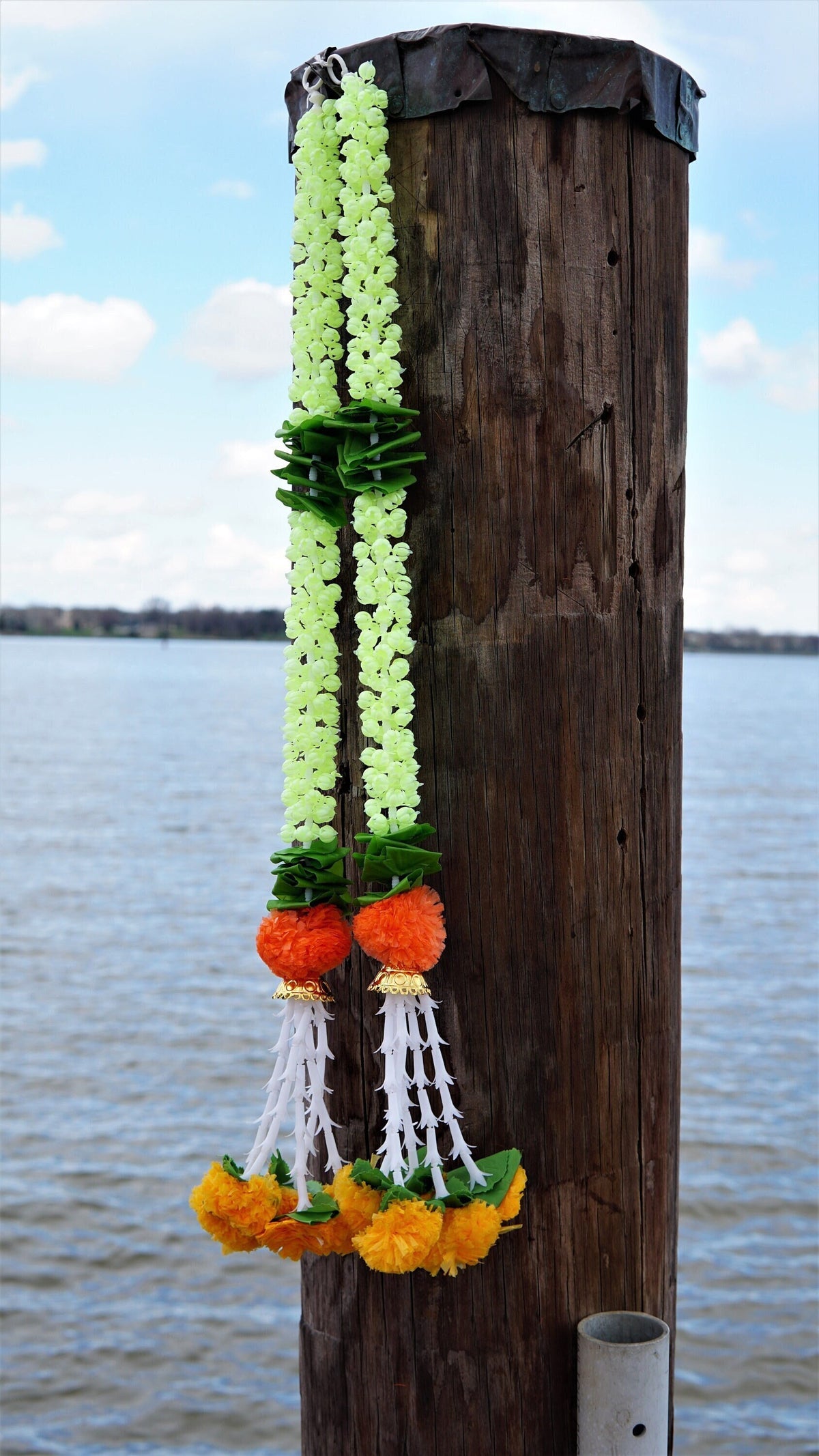 Pair of artificial jasmine garland hangings with green leaf accents, orange flowers and white bead-style tassels, 2.5 feet each