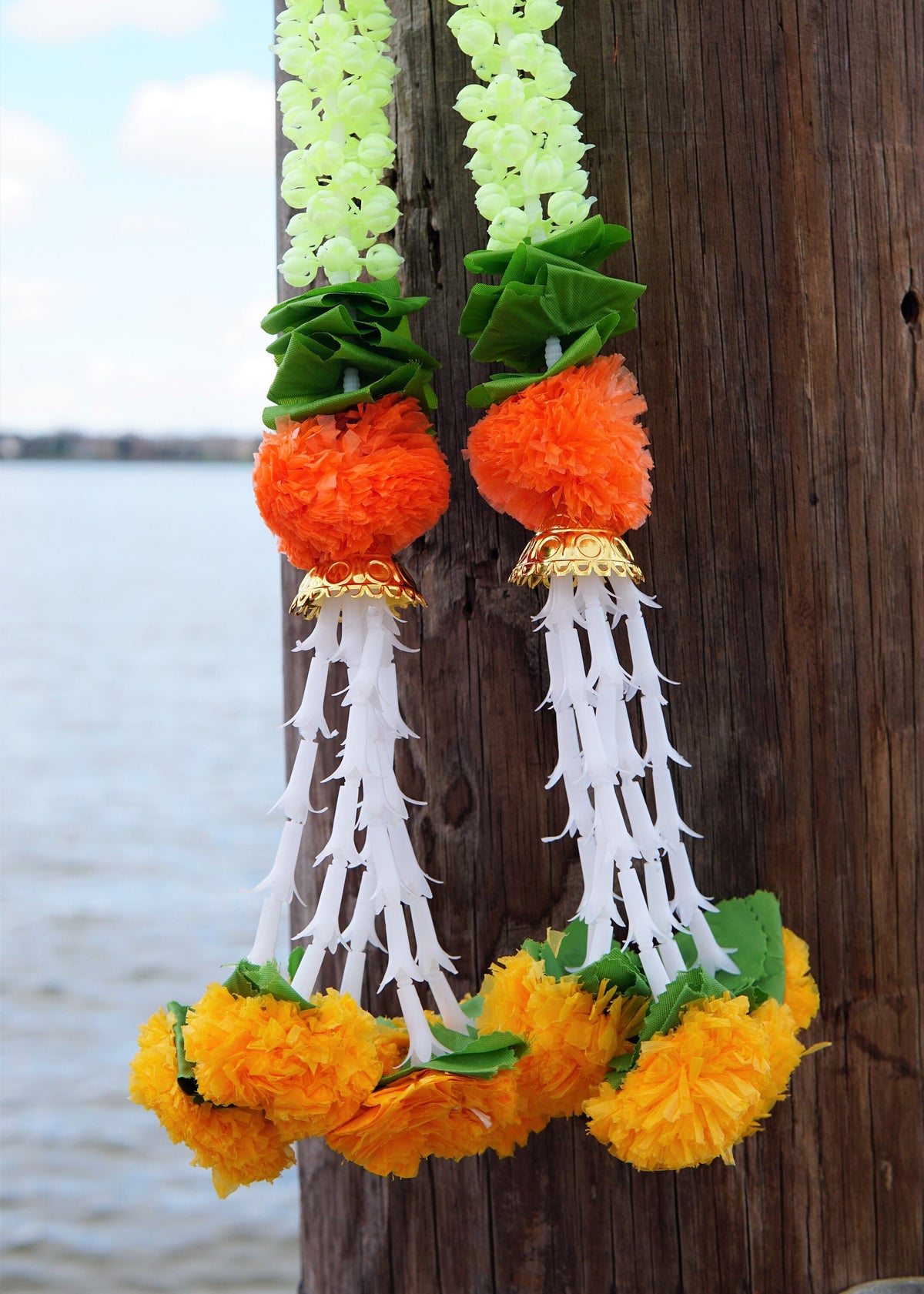 Detail of jasmine-style garland hangings with green accents and orange flowers