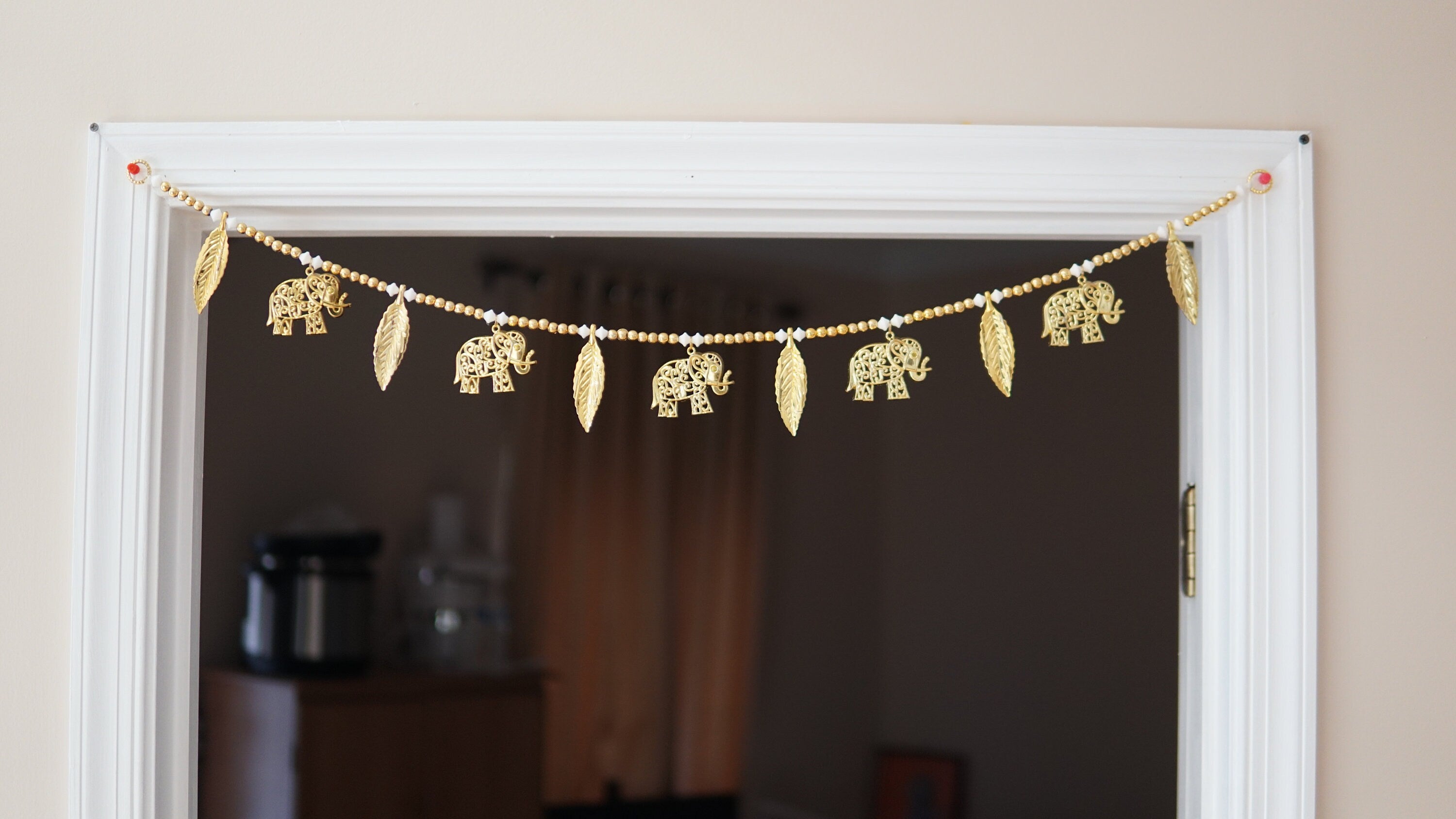 golden elphant toran with white and gold bead and leaves. Beautiful toran for Diwali, house warming and auspicious events and gift giving