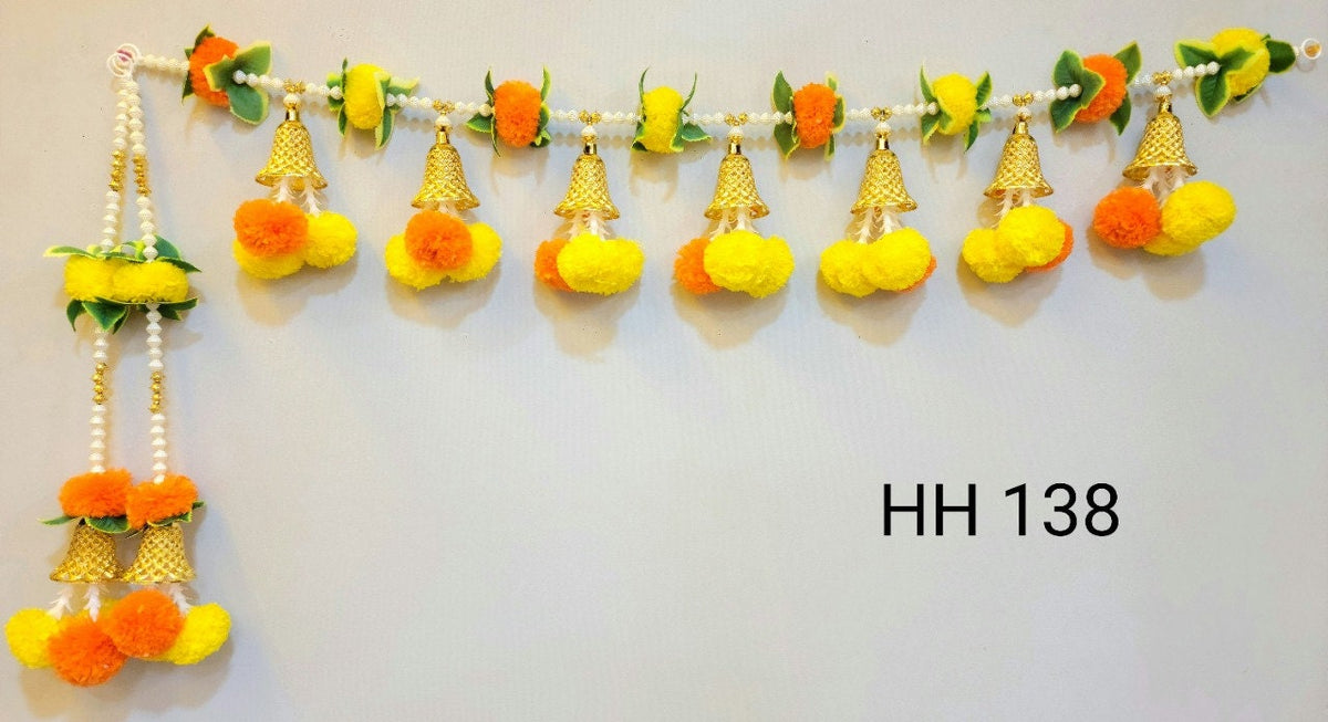 Detail of the orange and yellow pom-pom door toran and decorative hanging bells