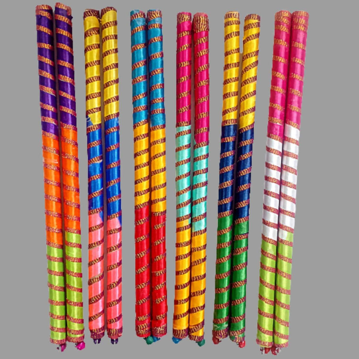 Assorted colorful ribbon-wrapped wooden dandiya sticks, Design 1; the pack includes 4 sticks